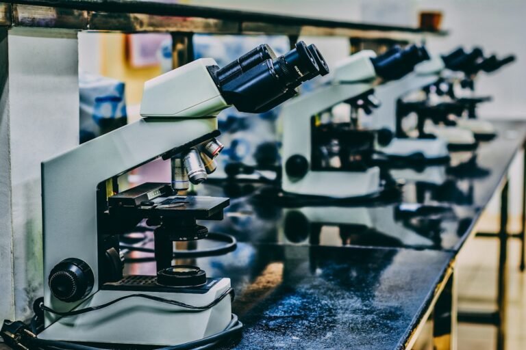 Microscópio branco sobre bancada de laboratório