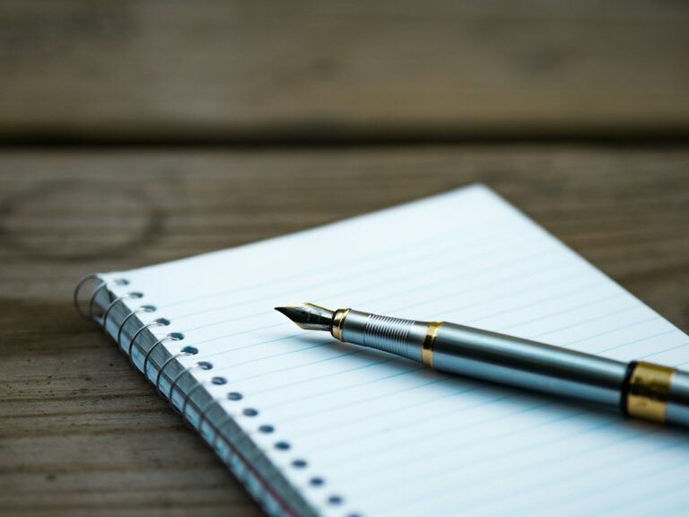 Caneta tinteiro apoiada sobre caderno aberto