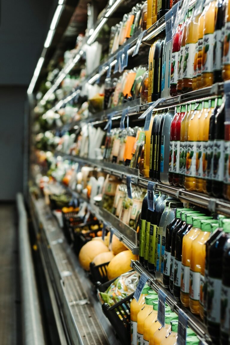 Prateleira de supermercado com bebidas e frutas expostas