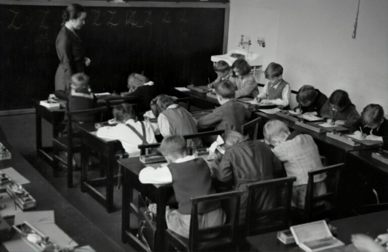Fotografia antiga de sala de aula com professor e alunos