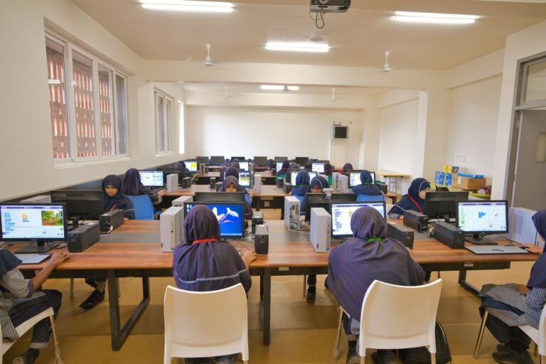 Estudantes trabalhando em computadores no laboratório de informática da escola