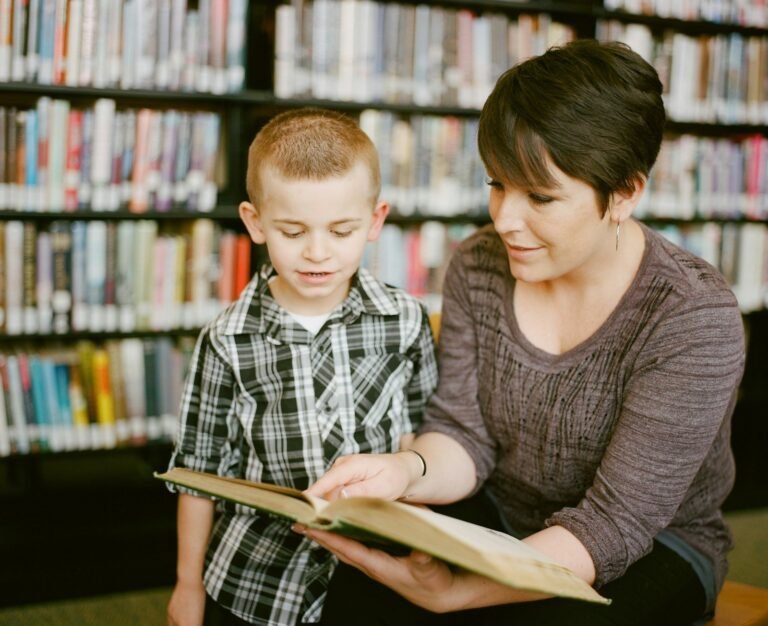 Educadora lendo livro com criança atenta na biblioteca