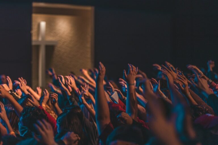 Fiéis com as mãos erguidas em culto